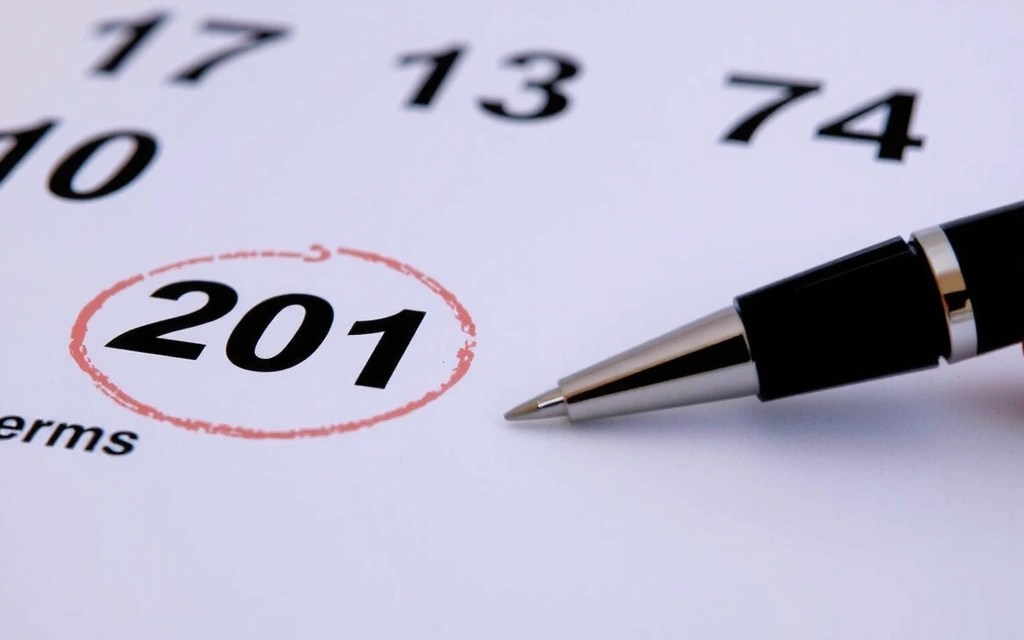 Ein Kalenderblatt mit einem hervorgehobenen Datum und einem Stift, der Änderungen symbolisiert